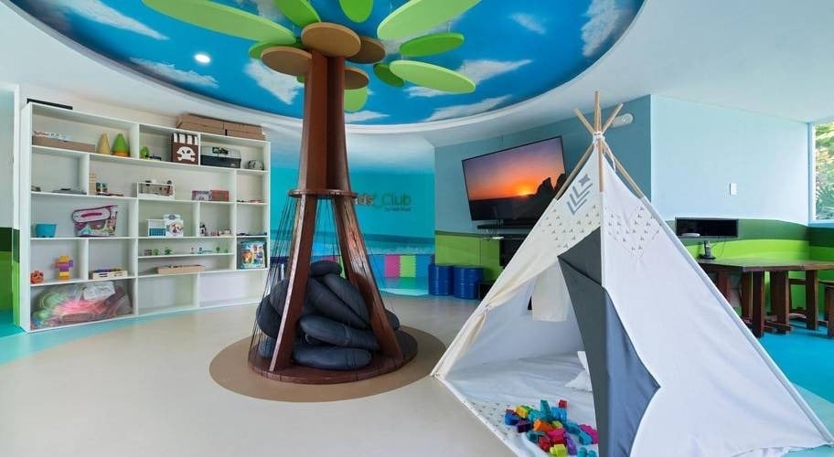 Zona infantil con columna en forma de árbol, juegos y tienda de indios del Hotel Park Royal Beach Cancún