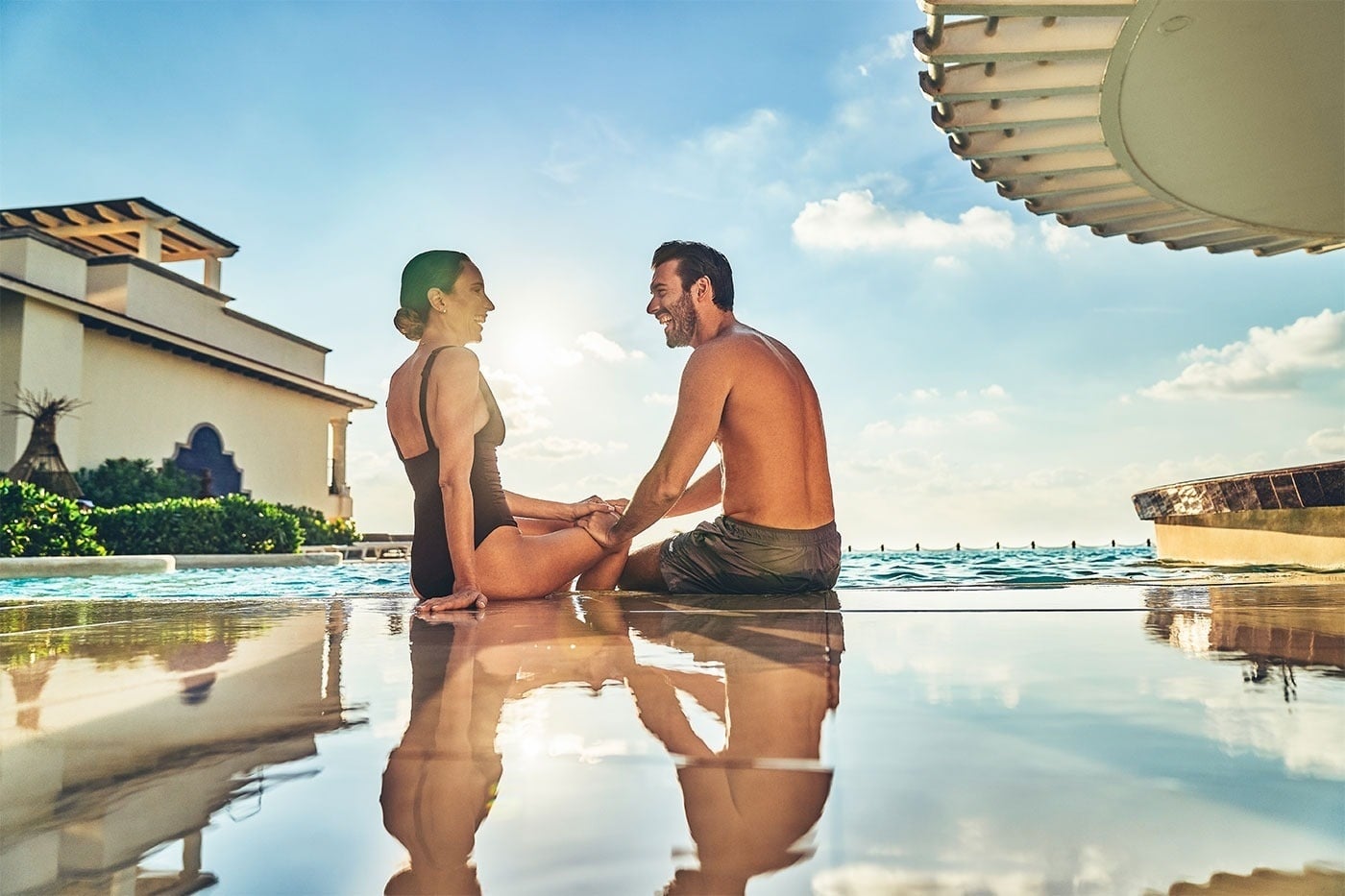 Couple relaxing by infinity pool, Hotel Grand Park Royal Cancun | Mexican Caribbean | Official Web
