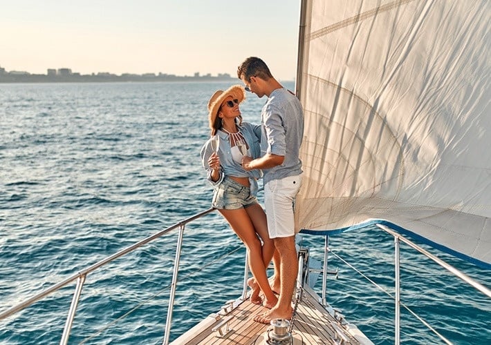 a man and a woman standing on a boat in the ocean