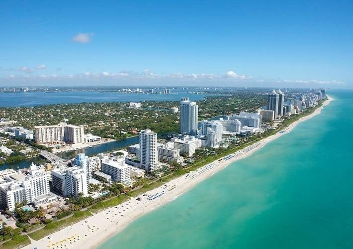 an aerial view of a beach with a city in the background .