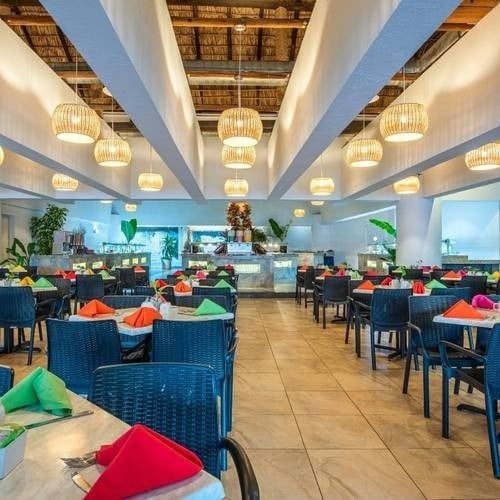 Sala de restaurante con sillas, mesas y lámparas del Hotel Park Royal Beach Huatulco