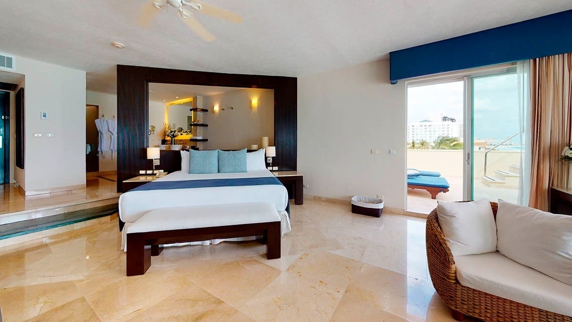 Quarto com cama king size, banheiro e terraço no Grand Park Royal Cancun Hotel
