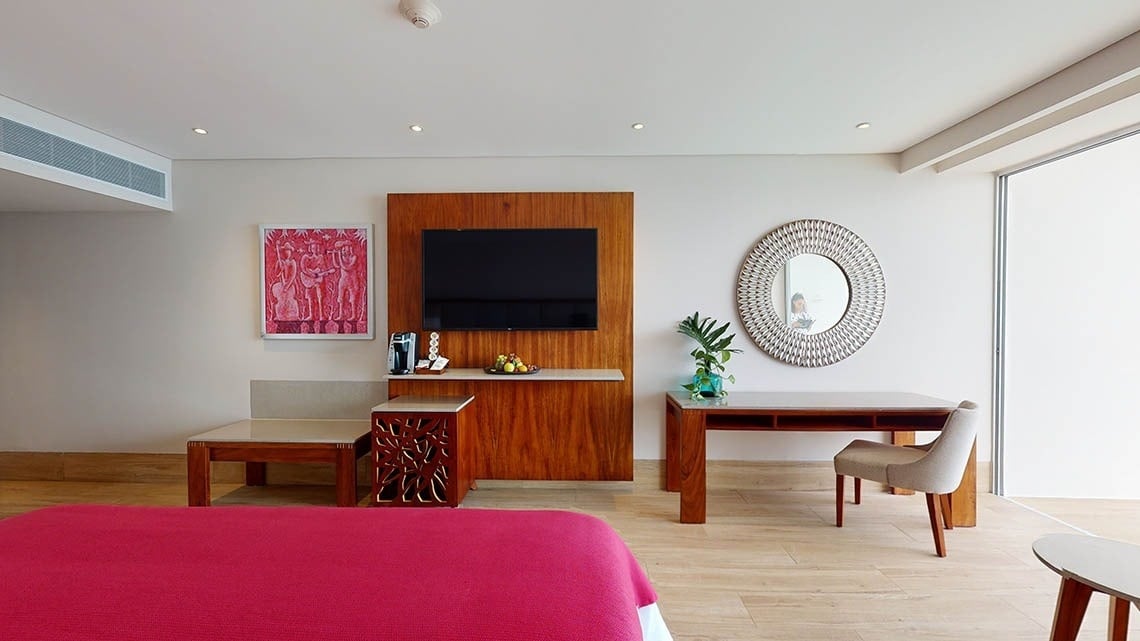 Dormitorio con espejo, mesas y sillón del Hotel Grand Park Royal Puerto Vallarta
