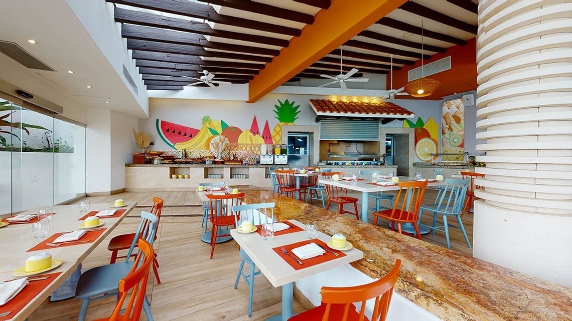 Mesas con sillas naranjas y azules del Hotel Grand Park Royal Puerto Vallarta