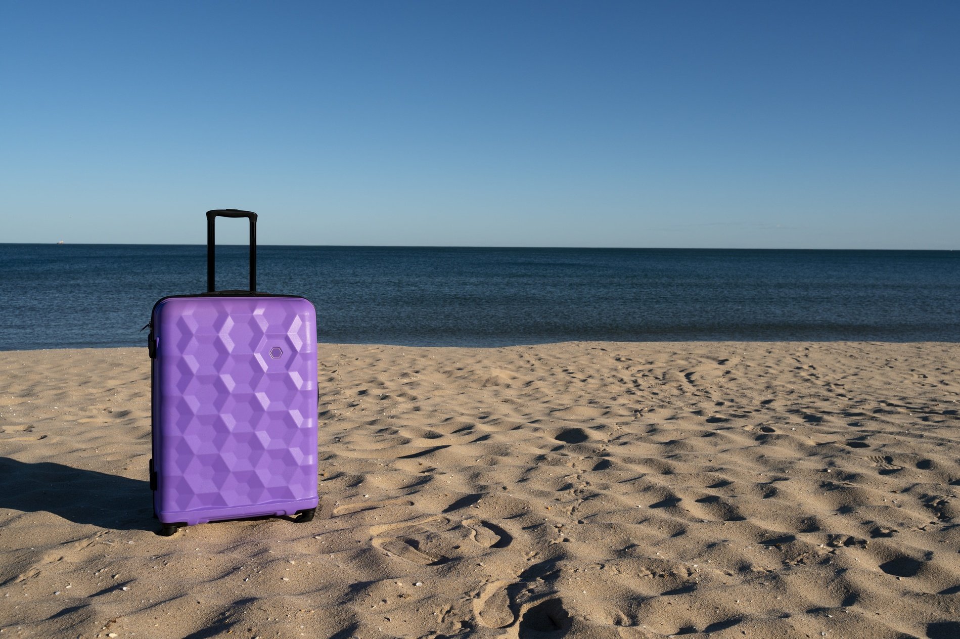 un grupo de personas se sienta en la playa con los brazos en el aire