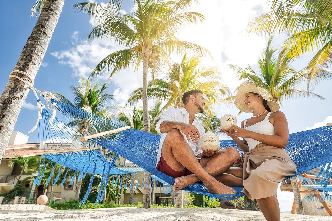 Pareja disfrutando cocos en hamaca. Royal Select en Grand Park Royal Cancún.
