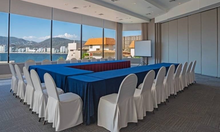 Sala de eventos con sillas y mesa en forma de U, con vistas al mar de Park Royal hoteles y resorts