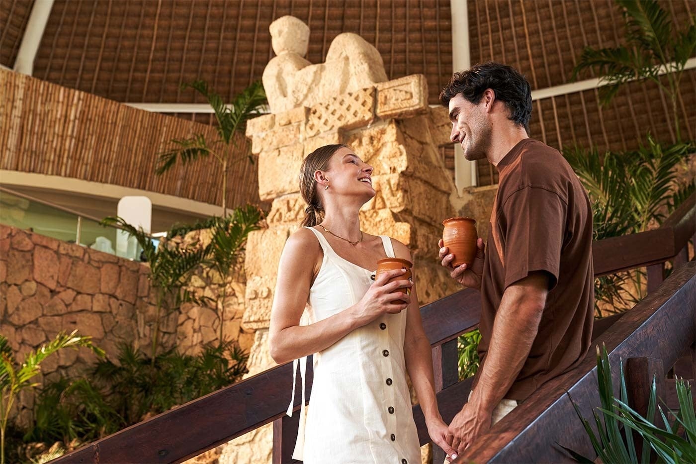 Pareja disfrutando bebidas en Park Royal: Corpo, rodeados de vegetación.