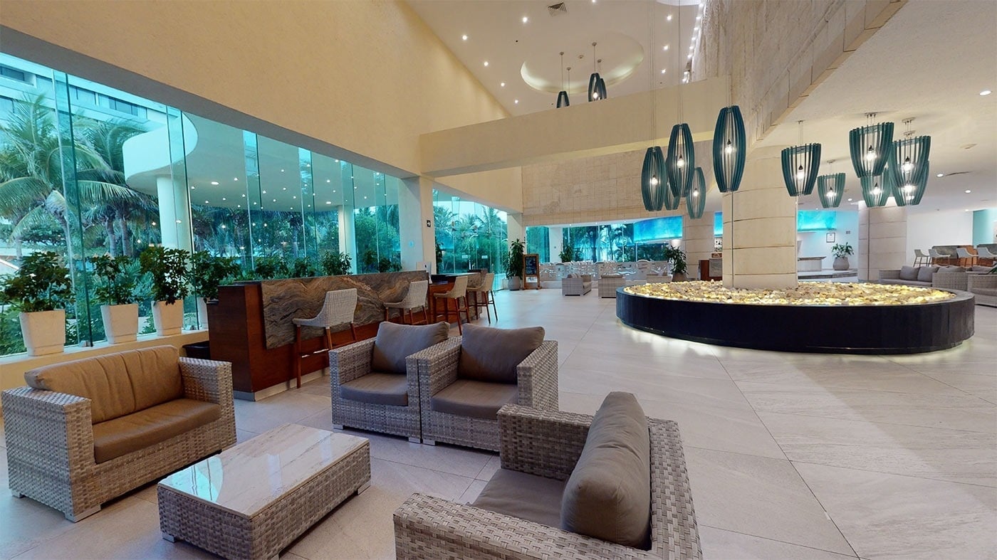 Hotel Park Royal Beach Cancún: lobby moderno con sofás, mesas y plantas; ideal para tu estancia en el Caribe Mexicano.