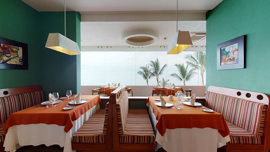 Mesas do restaurante italiano Andiamo com estilo aconchegante no Hotel Grand Park Royal Puerto Vallarta