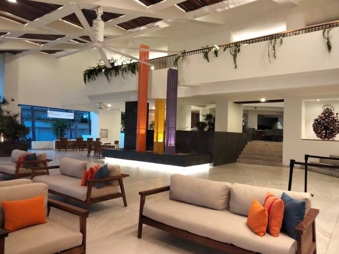 a lobby of a hotel with a couch and chairs