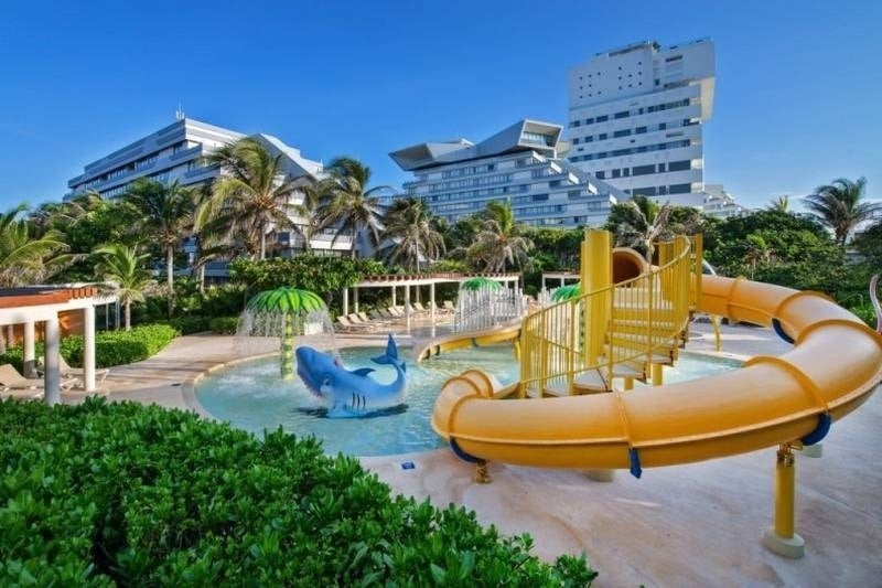 Parque acuático con toboganes, sombrilla de agua y animales en el Hotel Park Royal Beach Cancún