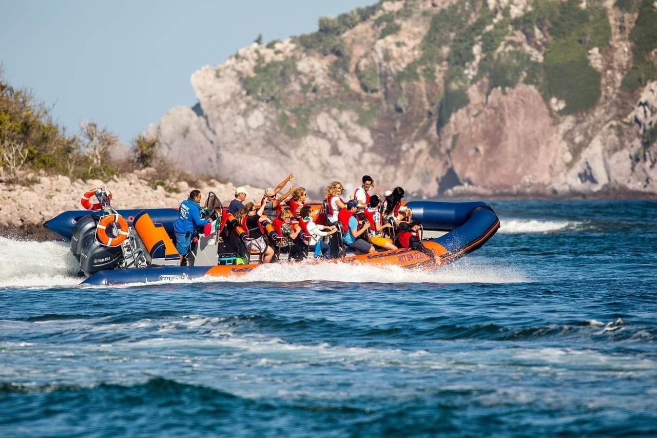 un grupo de personas en un bote inflable en el océano