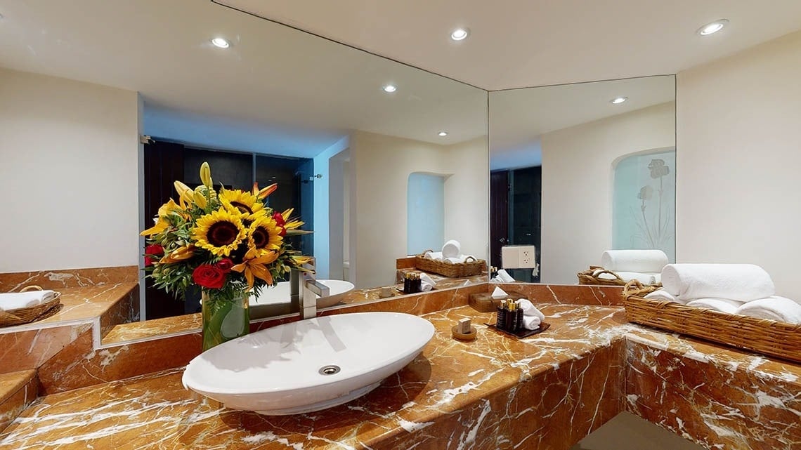 Lavabo de mármol con espejos y flores del Hotel Grand Park Royal Puerto Vallarta