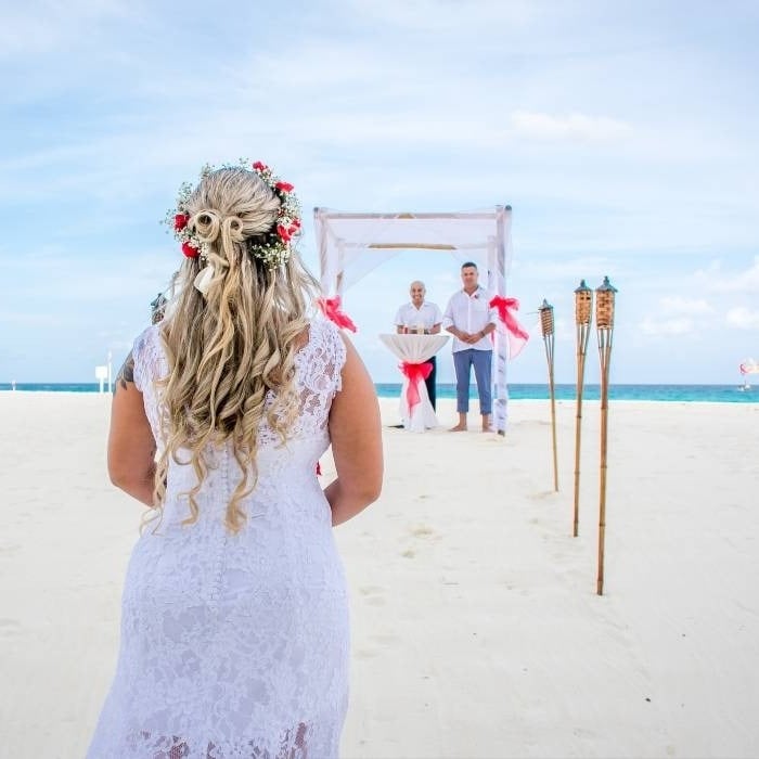 Noiva se aproximando do altar, na praia de The Villas by Grand Park Royal Cancun