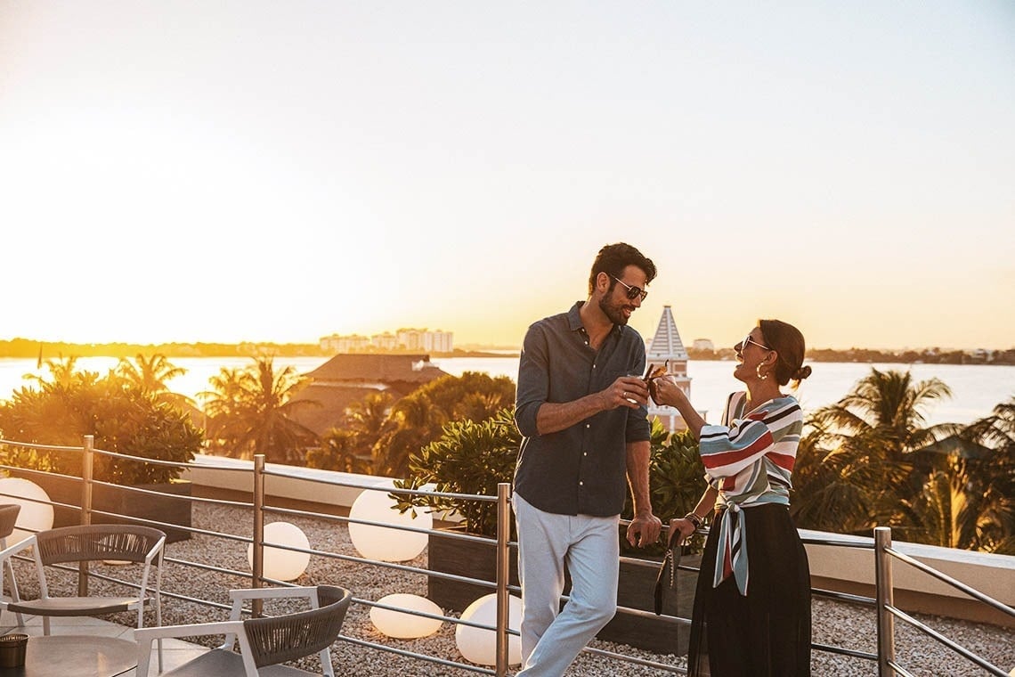 Couple having a drink on the terrace of The Villas by Grand Park Royal Cancun