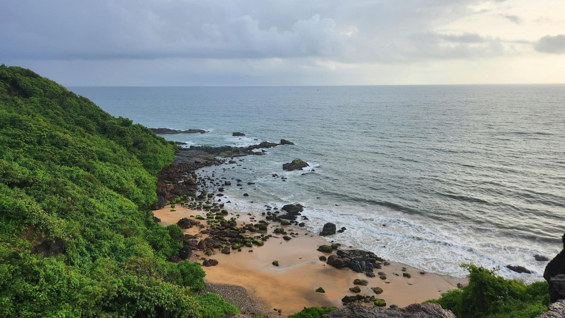 una playa llena de rocas y árboles junto al océano