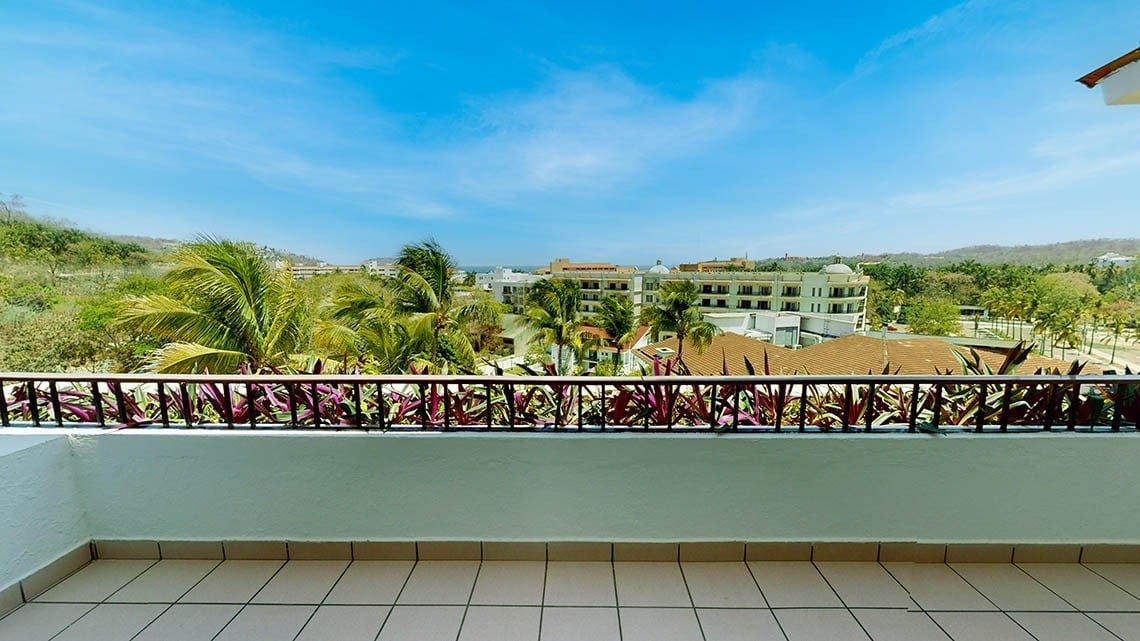 a balcony with a view of palm trees and buildings