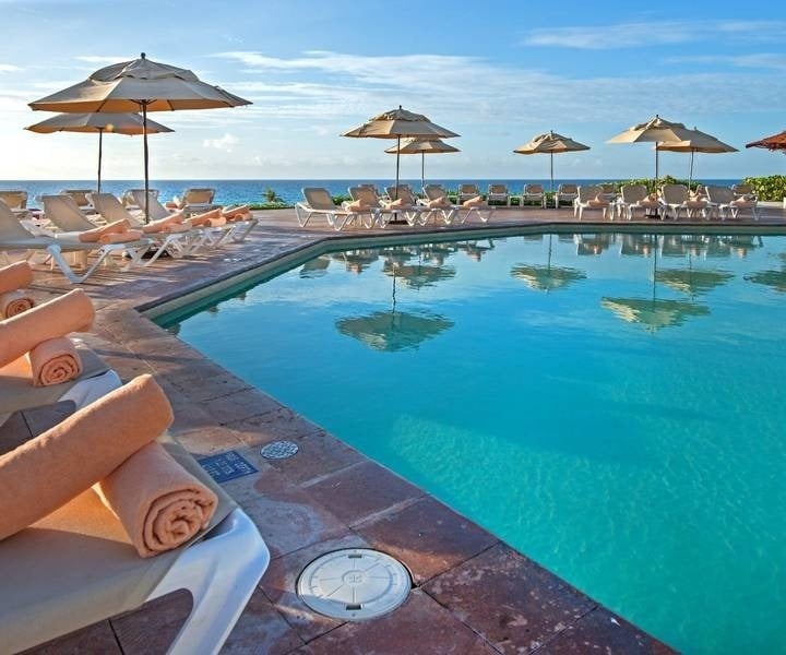 Hamacas con sombrillas en piscina con vistas al mar del Hotel Park Royal Beach Cancún
