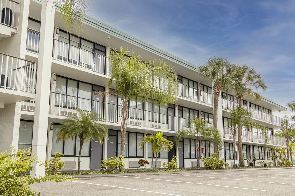 a hotel with a lot of windows and palm trees