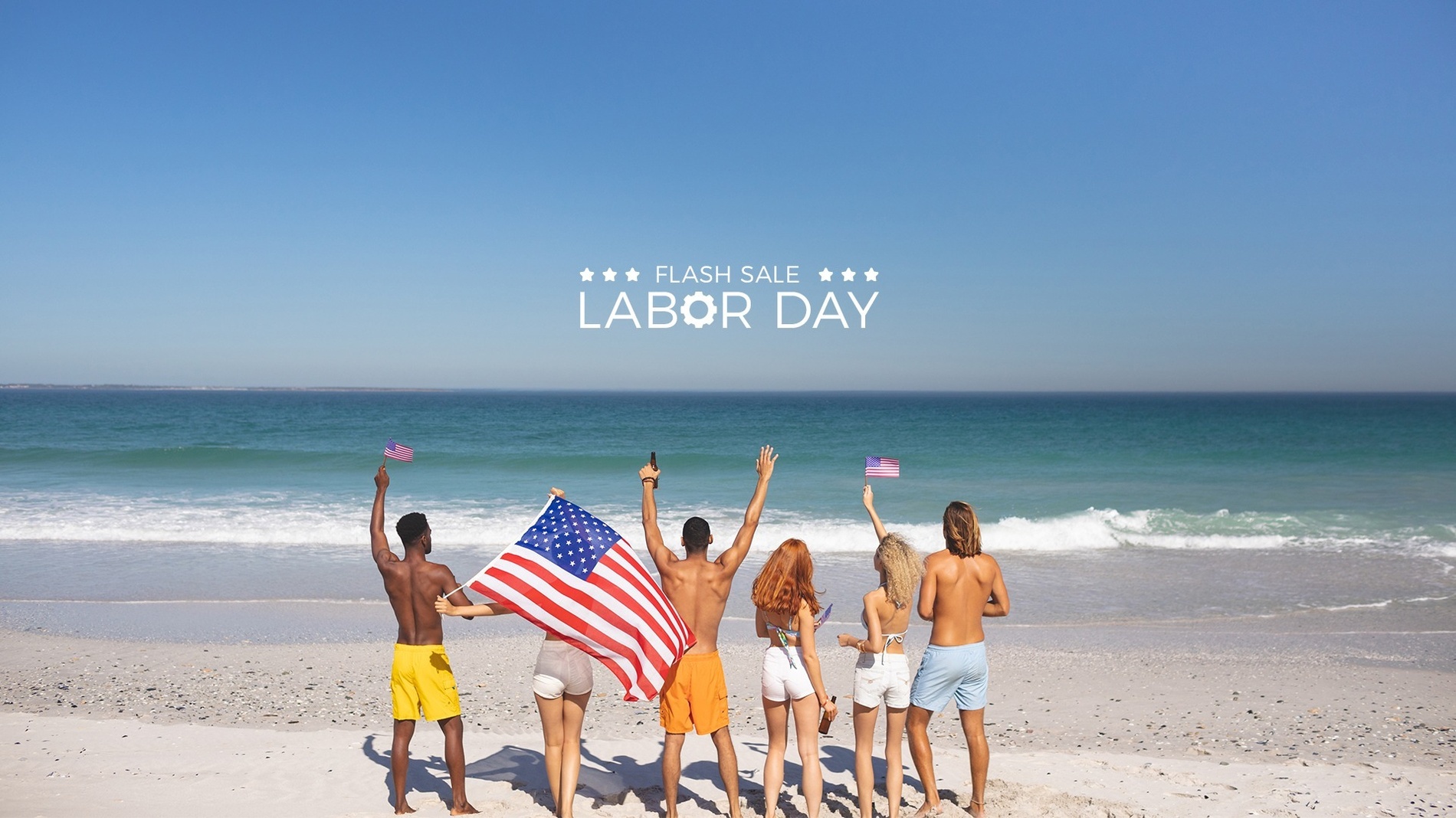a group of people standing on a beach holding american flags
