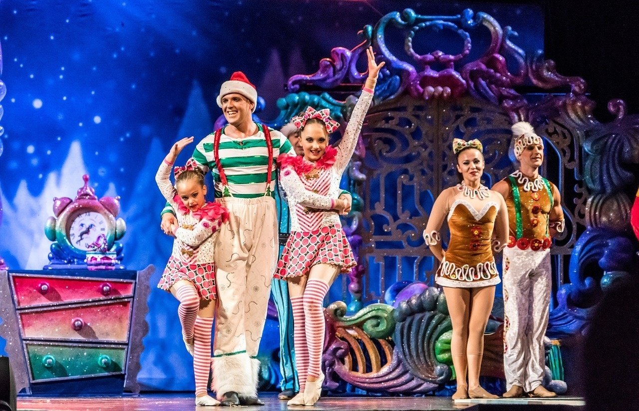 a group of people on a stage with one wearing a gingerbread outfit