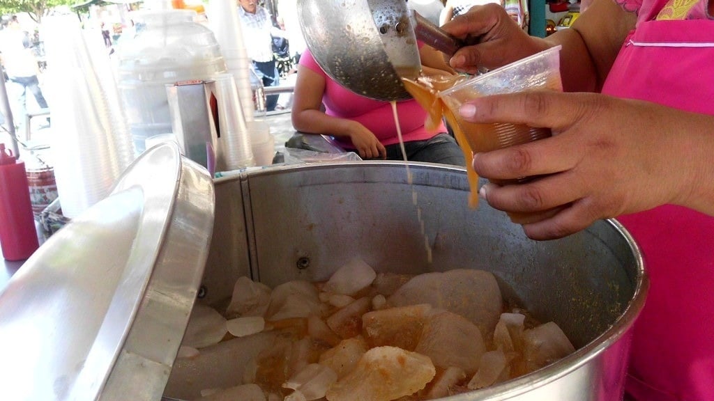 Vendedora sirviendo un vaso de Tejuino