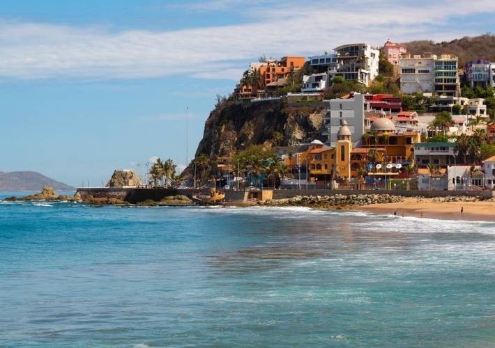 uma praia com muitos prédios ao longo de uma colina com vista para o oceano