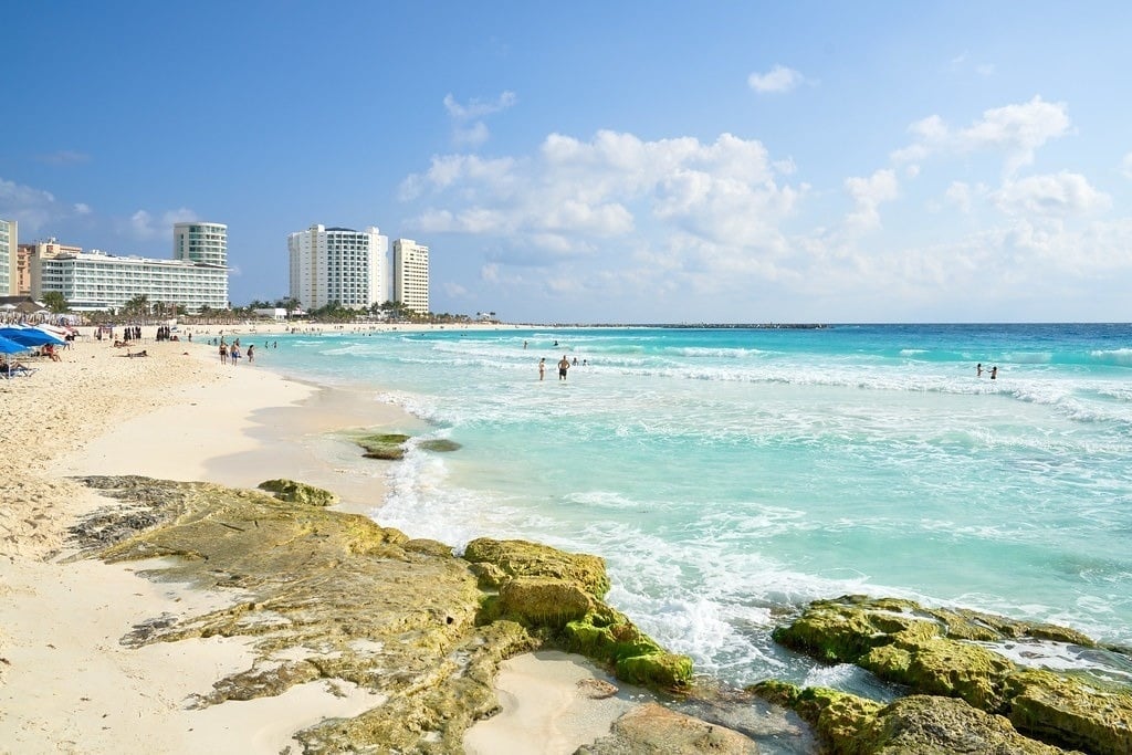 a beach scene with a hotel in the background