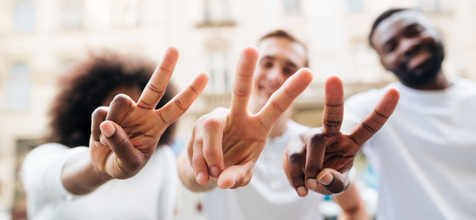 three people are making a peace sign with their hands