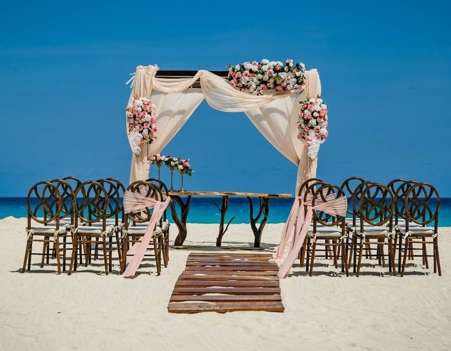 Altar de casamento e cadeiras decoradas com flores em uma praia no México, Park Love by Park Royal hotéis e resorts