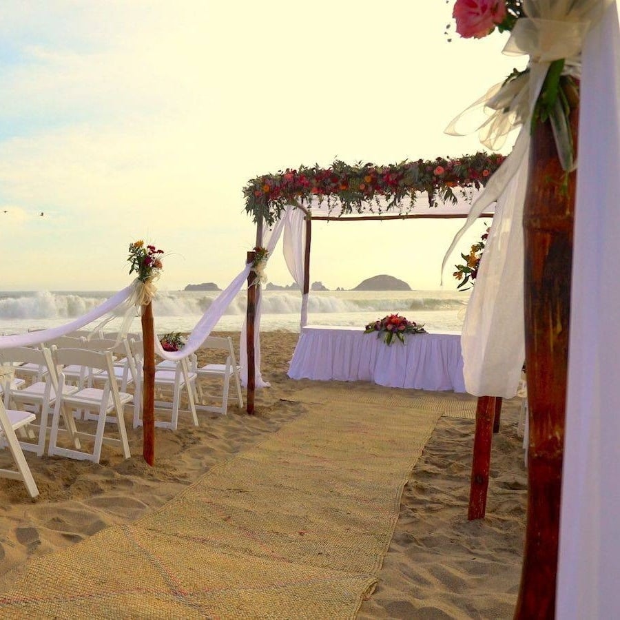 Altar y sillas decoradas para boda en la playa del Hotel Grand Park Royal Puerto Vallarta 