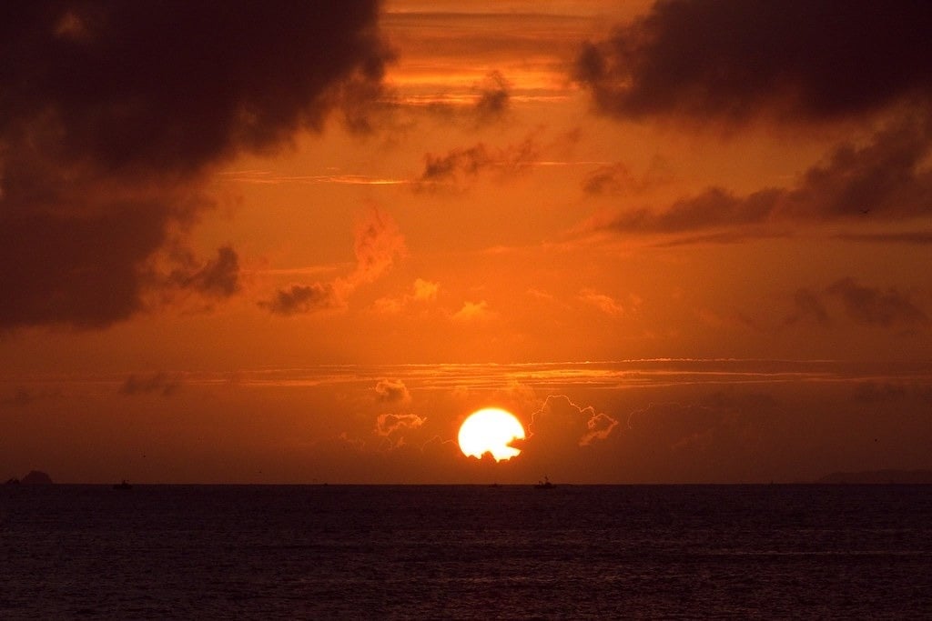 o sol está se pondo sobre o oceano