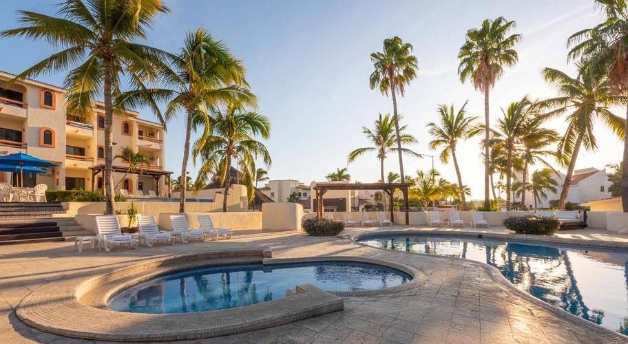 Vista de várias piscinas ao ar livre cercadas por palmeiras no Homestay Los. Cabos no México
