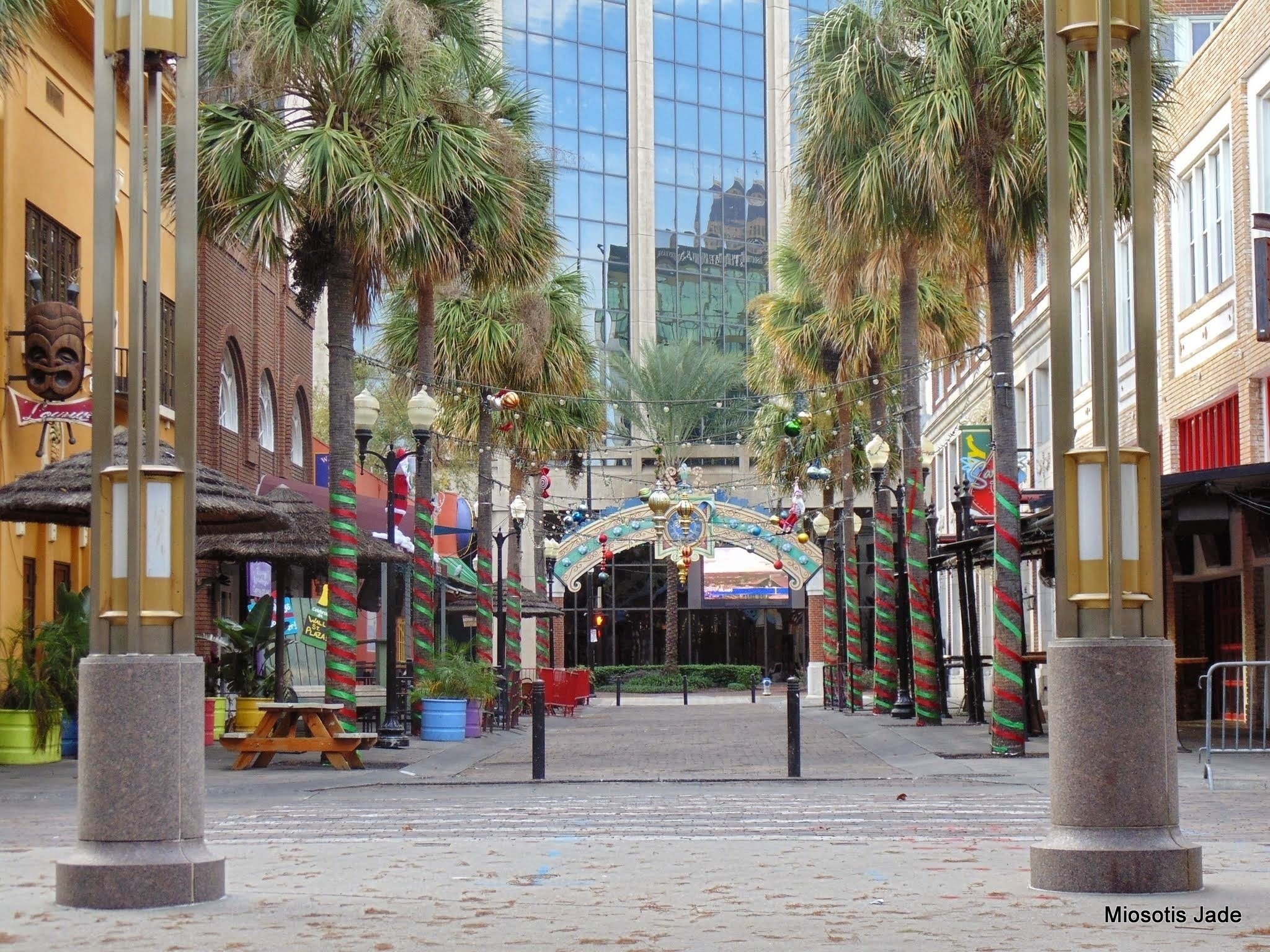 palmeras decoradas con cintas rojas y verdes en un centro comercial