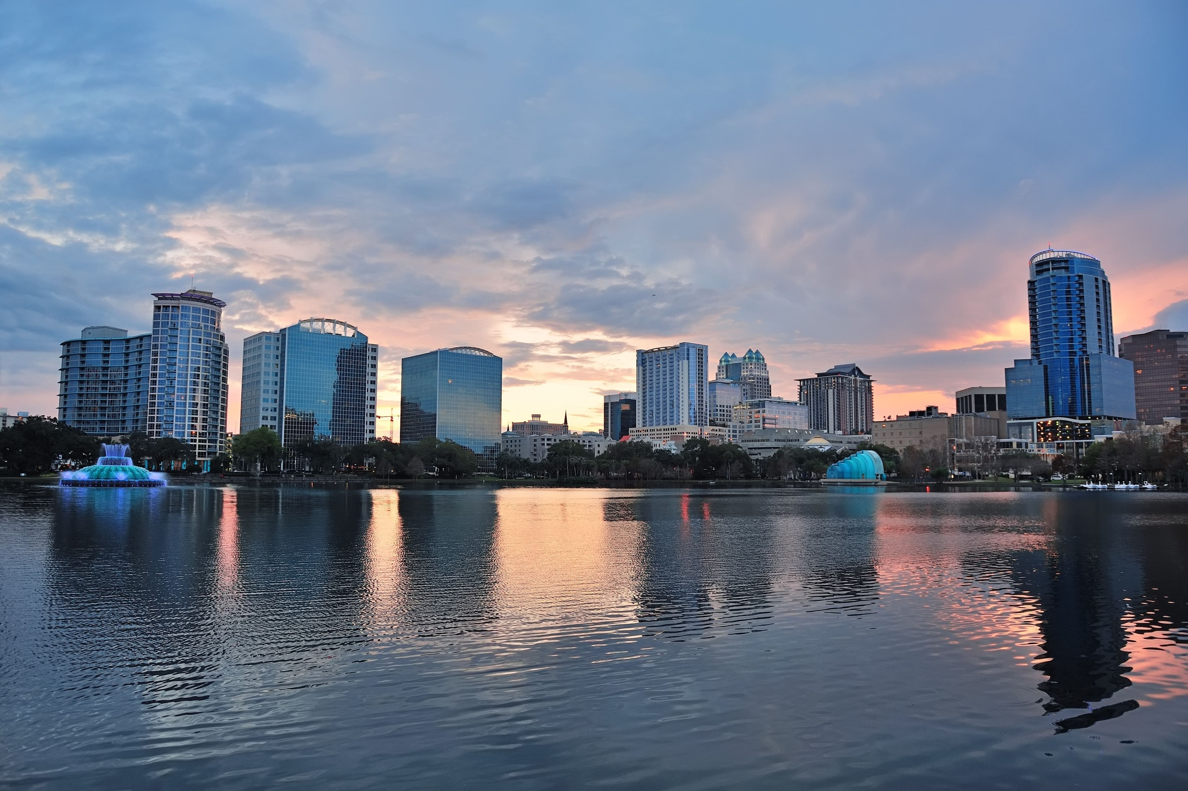 el horizonte de la ciudad se refleja en un lago al atardecer