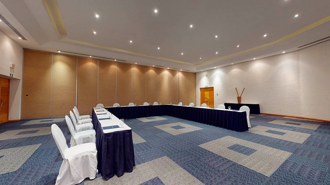 Panorámica de una sala de eventos con mesas en forma de U del Hotel Grand Park Royal Cozumel