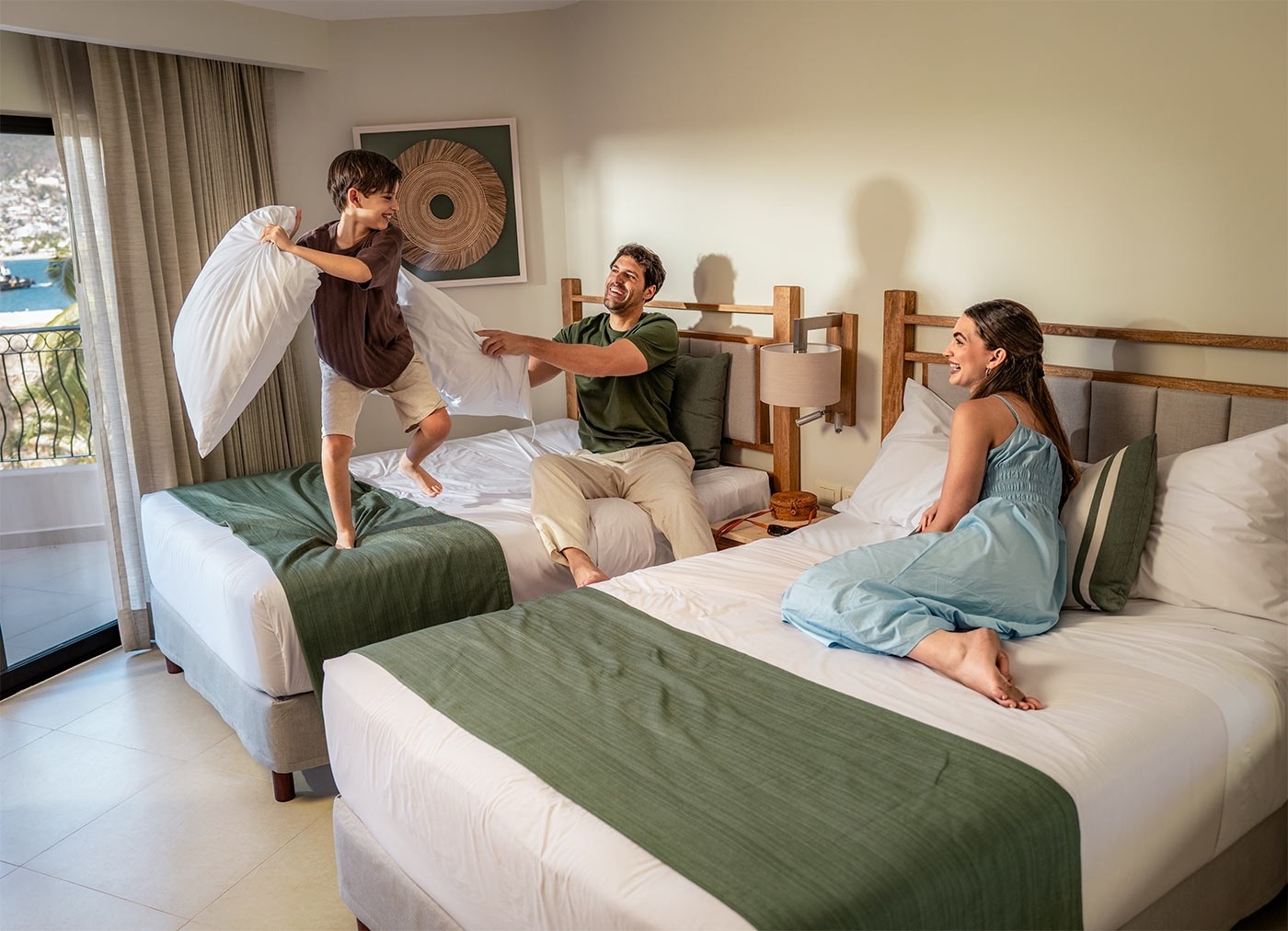 Familia feliz jugando con almohadas en Hotel Park Royal Beach Acapulco.