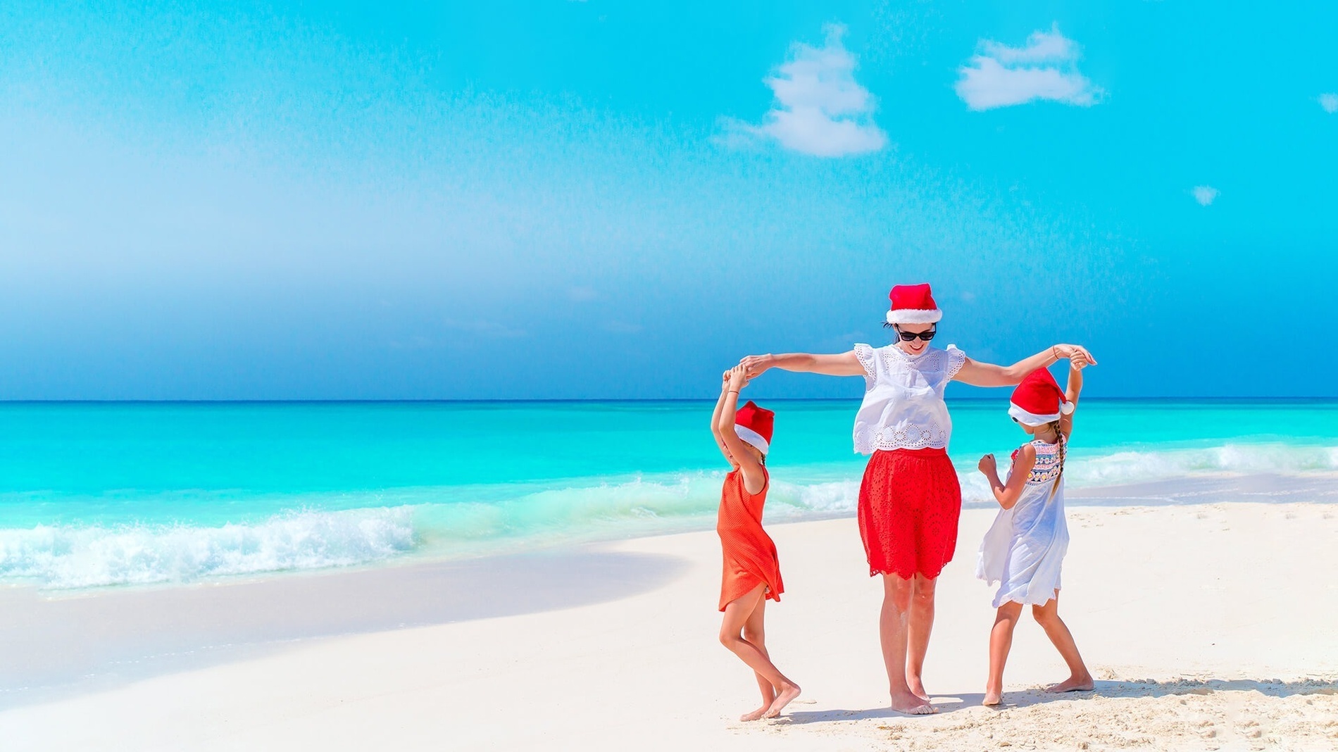 uma mãe e suas duas filhas aproveitando o Natal na praia com Park Royal