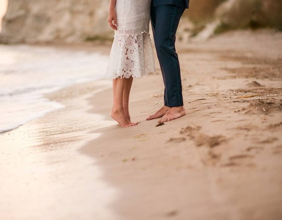 Legs of the bride and groom on the shore of the beach of the Hotel Grand Park Royal Puerto Vallarta in the Mexican Pacific