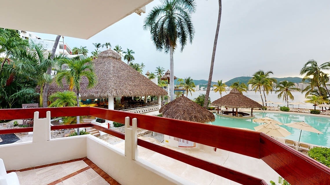 Terrace with views of the outdoor pool and the Pacific Ocean at the Park Royal Beach Acapulco Hotel