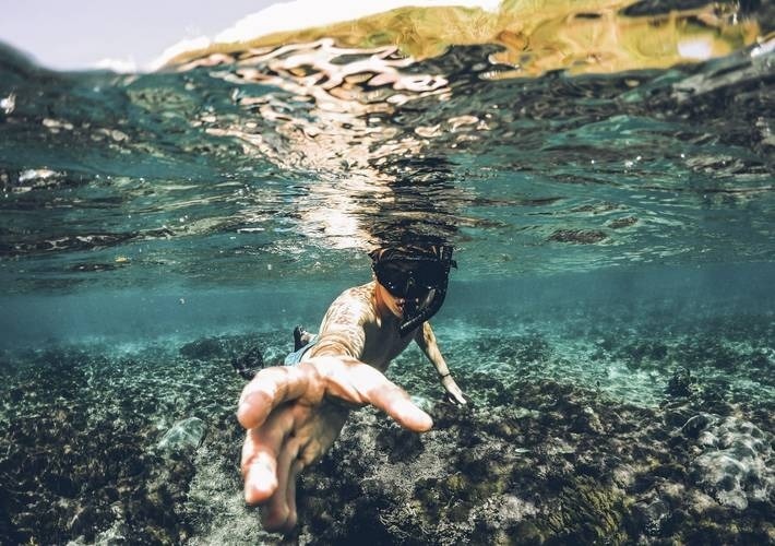 a person wearing a mask is swimming in the ocean