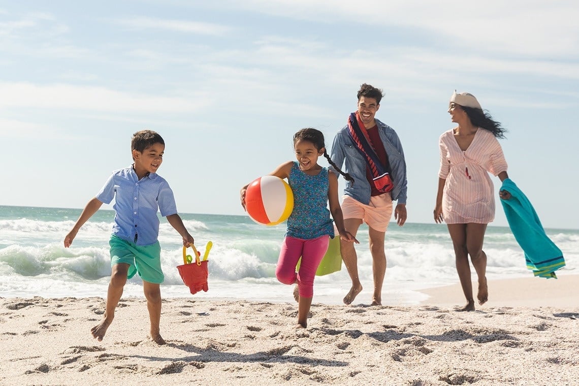 a boy and a girl are playing in the sand on the beach