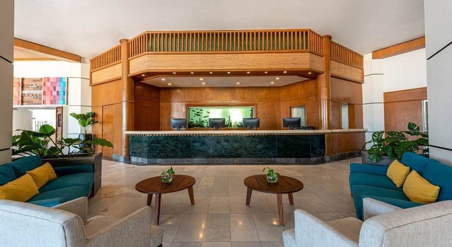 Reception area with armchairs, tables and fish tank at Park Royal Beach Acapulco, Mexico