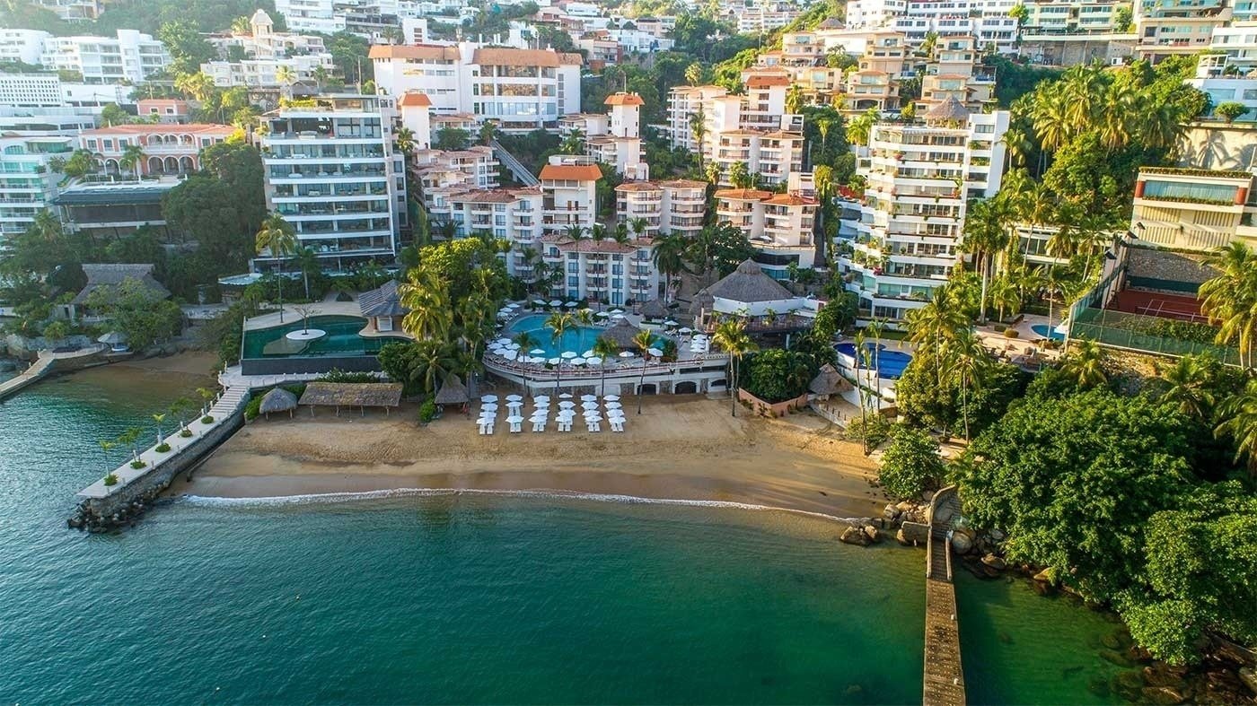 vista aérea de um resort com piscinas e praia