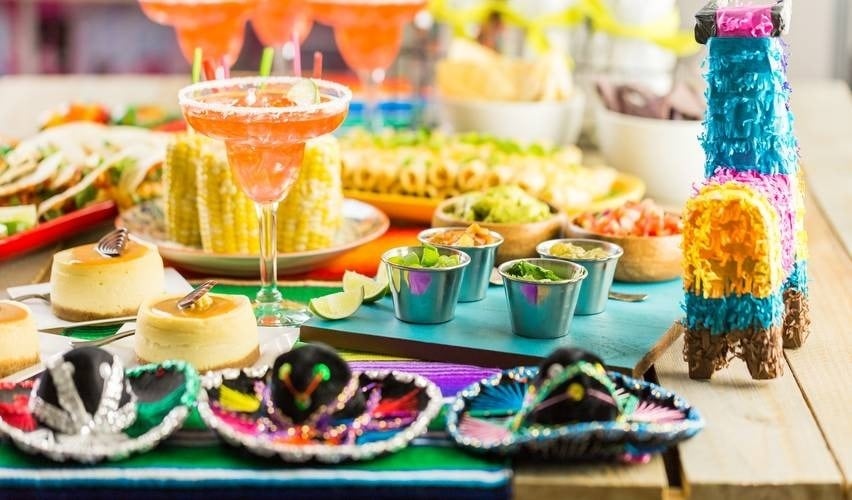 a table topped with a variety of mexican food and drinks .