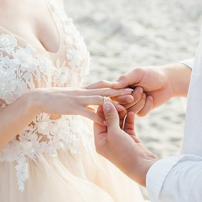 Groom putting the ring on the bride on the beach of the Hotel Park Royal Beach Acapulco