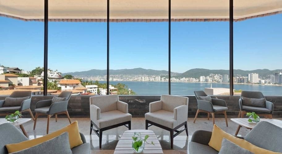 Area of armchairs and tables overlooking the sea in Park Royal Acapulco, Mexico