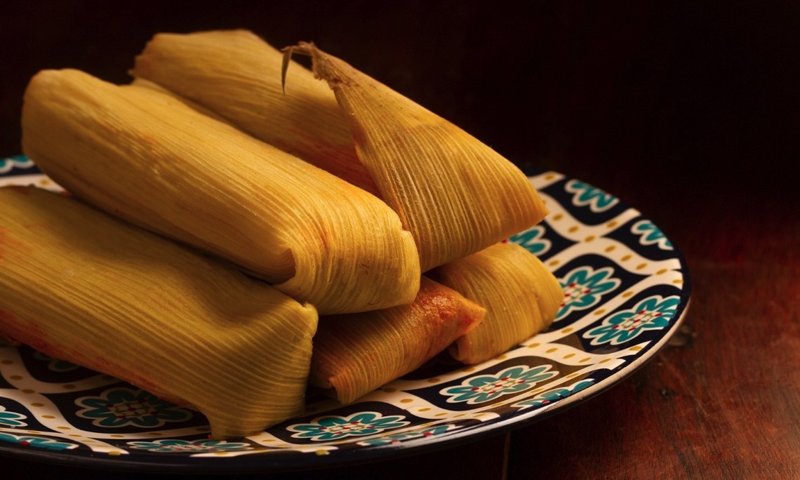 dos tamales están sobre un plato blanco