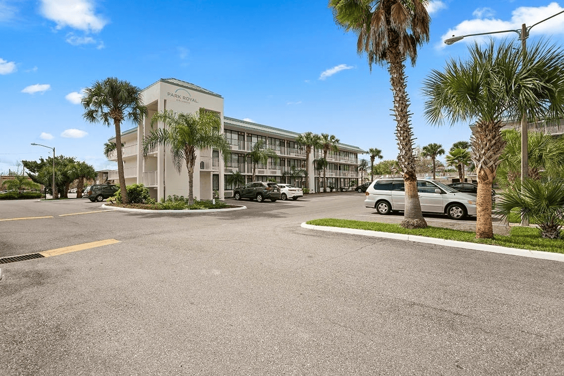 a park royal hotel is surrounded by palm trees